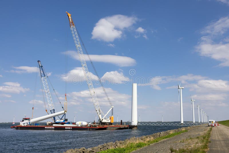 Lelystad, The Netherlands - April 22, 2022: Crane ship and supply vessel busy with demolition old offshore wind turbine. Lelystad, The Netherlands - April 22, 2022: Crane ship and supply vessel busy with demolition old offshore wind turbine