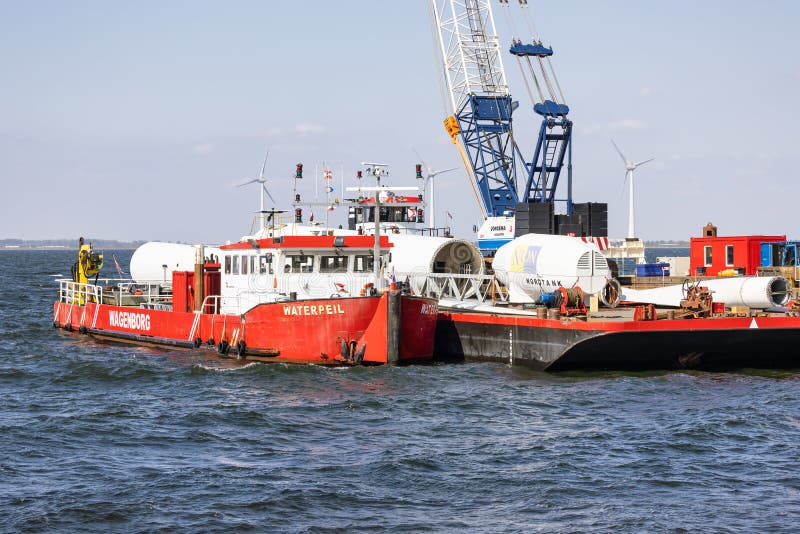 Lelystad, The Netherlands - April 22, 2022: Crane ship and supply vessel busy with demolition old offshore wind turbine. Lelystad, The Netherlands - April 22, 2022: Crane ship and supply vessel busy with demolition old offshore wind turbine