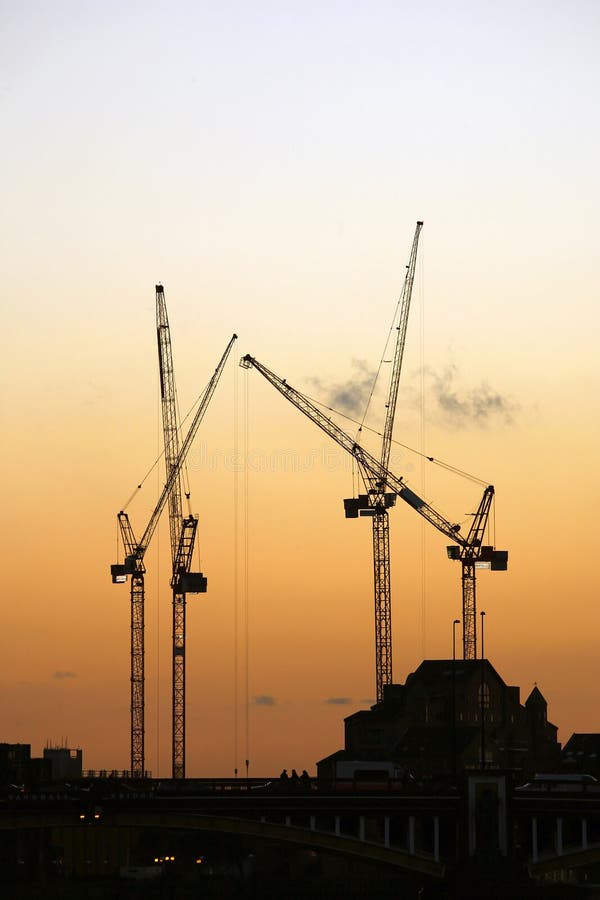 Cranes working over sunset