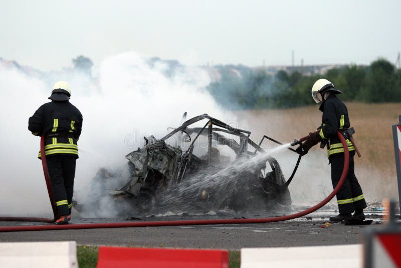 Crash on a motorway firefighters extinguish a burning car stock images Crash on a motorway firefighters extinguish a burning car stock images