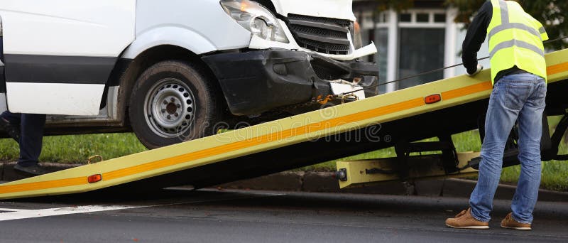 Crashed minibus is loaded onto tow truck after an accident.