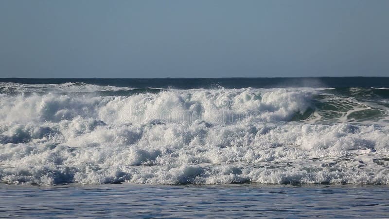 Crashing waves over against blue sky along Pacific Ocean in Cannon Beach Oregon