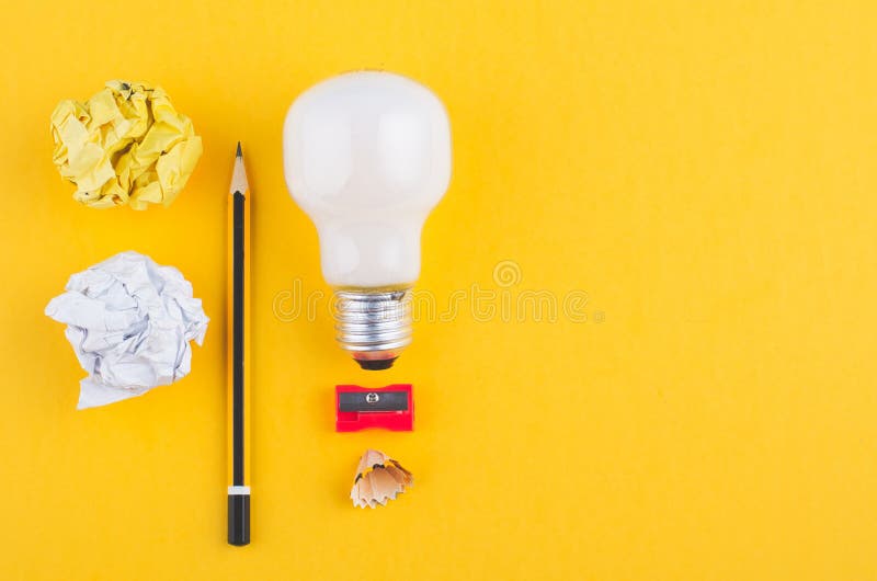 Crayonnez, chiffonnez le papier et l'ampoule au-dessus du fond jaune image libre de droits Crayonnez, chiffonnez le papier et l'ampoule au-dessus du fond jaune image libre de droits