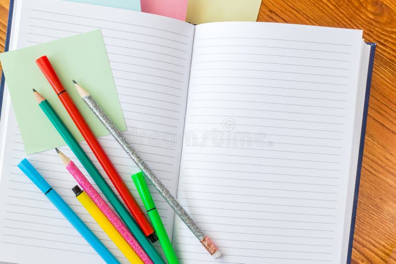 Crayons colorés et stylos feutres sur le carnet rayé image libre de droits Crayons colorés et stylos feutres sur le carnet rayé image libre de droits