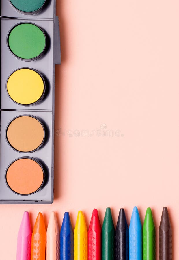 Crayons and paints of different colors on a beige background. Copy space stock photography
