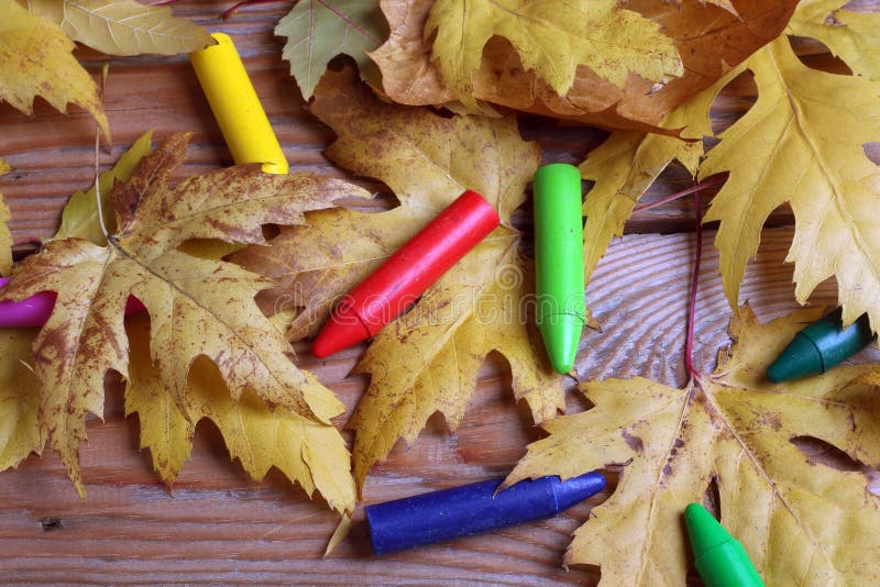 Oil pastel crayons lying on a paper with painted rainbow Stock