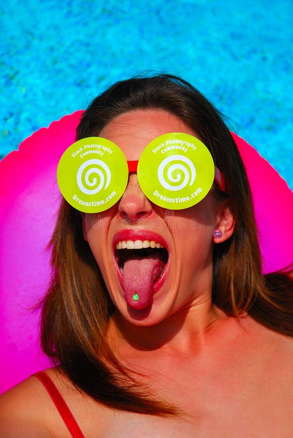 Caucasian white woman going crazy about the Dreamstime fashion with Dreamstime logo tongue piercing and Dreamstime sunglasses. Caucasian white woman going crazy about the Dreamstime fashion with Dreamstime logo tongue piercing and Dreamstime sunglasses.