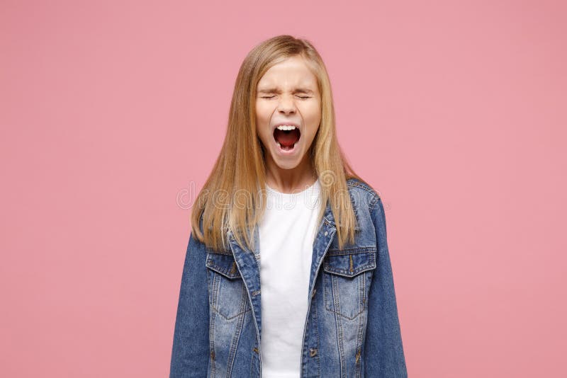 Crazy little blonde kid girl 12-13 years old in denim jacket isolated on pastel pink wall background children portrait