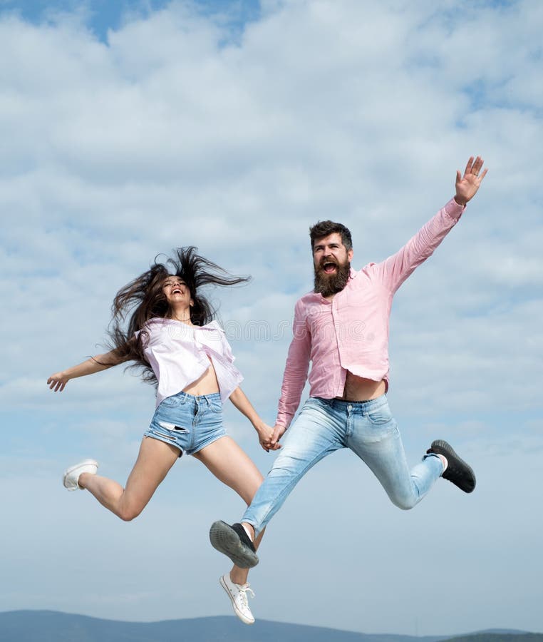 Crazy in love. Woman and man jump in cloudy sky. Enjoy carefree time together. Summer vacation. Feeling freedom. Playful stock photos Crazy in love. Woman and man jump in cloudy sky. Enjoy carefree time together. Summer vacation. Feeling freedom. Playful stock photos