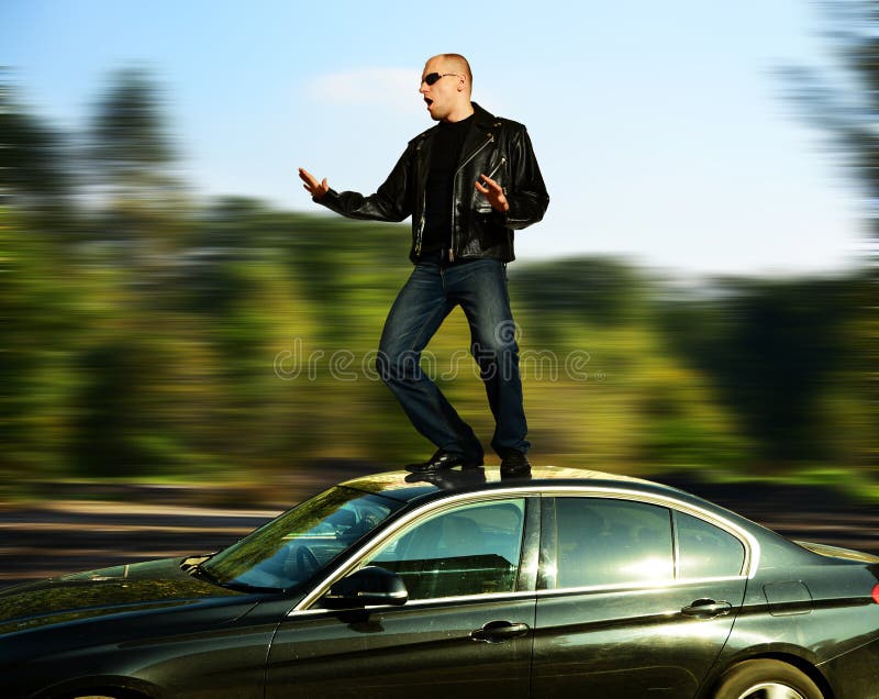 Matto uomo, in piedi sul veloce auto in movimento.