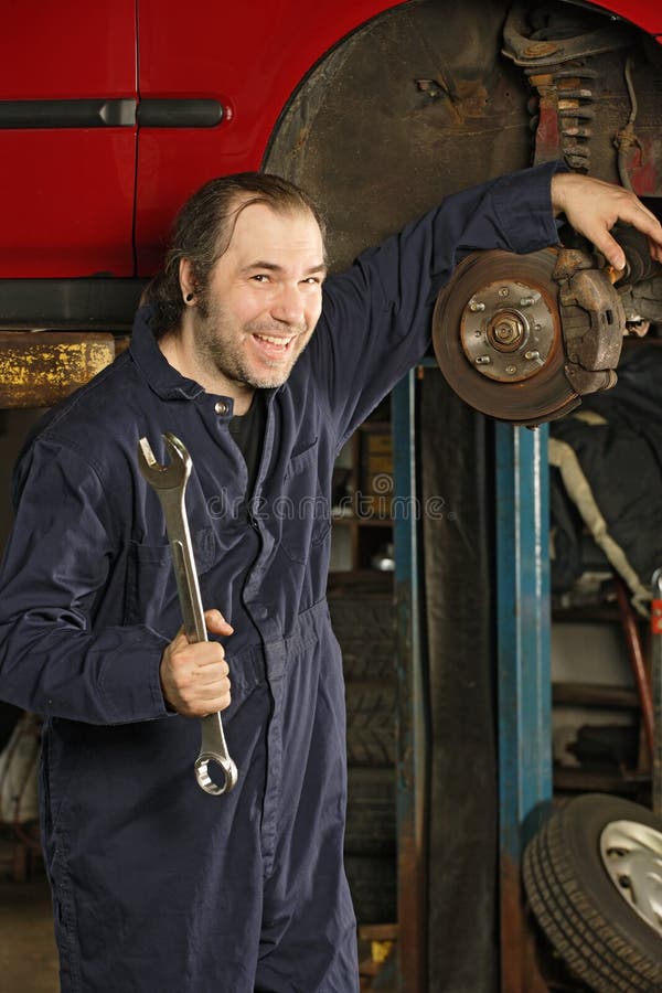 Crazy mechanic fixing the brakes royalty free stock image