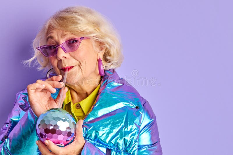 Crazy stylish woman drink beverage from colourful bottle stock photo