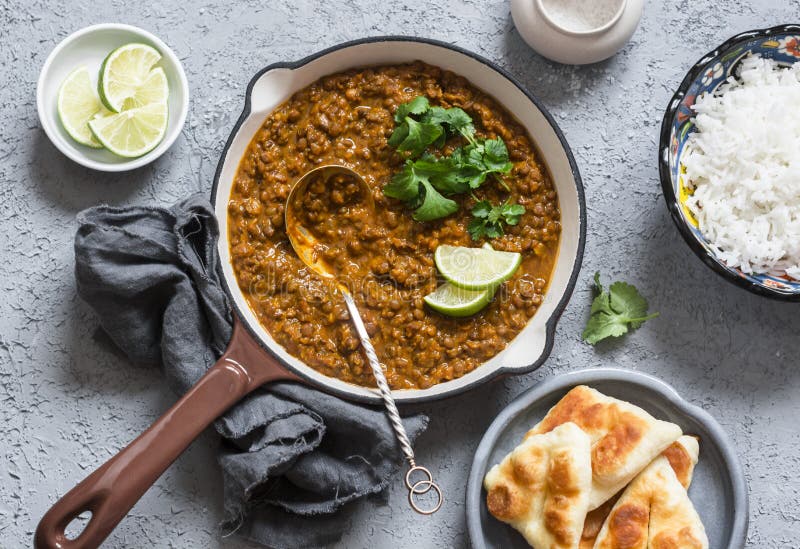 Cream coconut lentil curry, rice, naan bread - vegetarian lunch buffet. Top view, flat lay