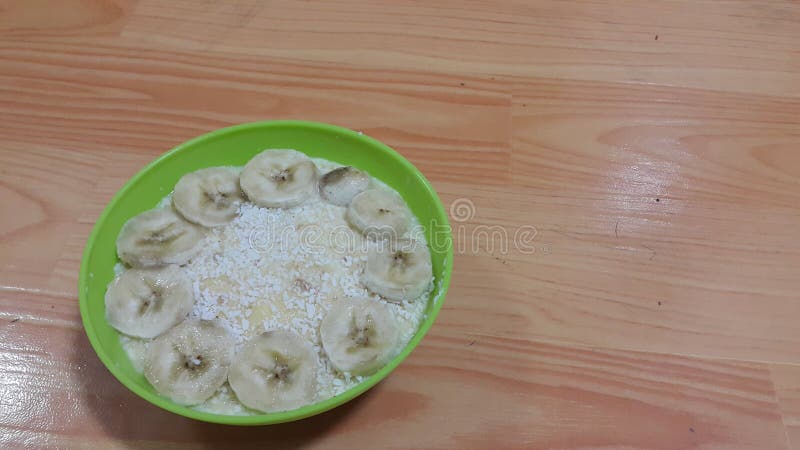 Creamy tasty sweet custard with banana pieces on surface inbowl on wooden floor. Creamy tasty sweet custard with banana pieces layered on surface on wooden floor stock photo Creamy tasty sweet custard with banana pieces on surface inbowl on wooden floor. Creamy tasty sweet custard with banana pieces layered on surface on wooden floor stock photo