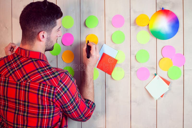 Creatieve arbeider die muur voor uitwisseling van ideeën gebruiken stock fotografie Creatieve arbeider die muur voor uitwisseling van ideeën gebruiken stock fotografie