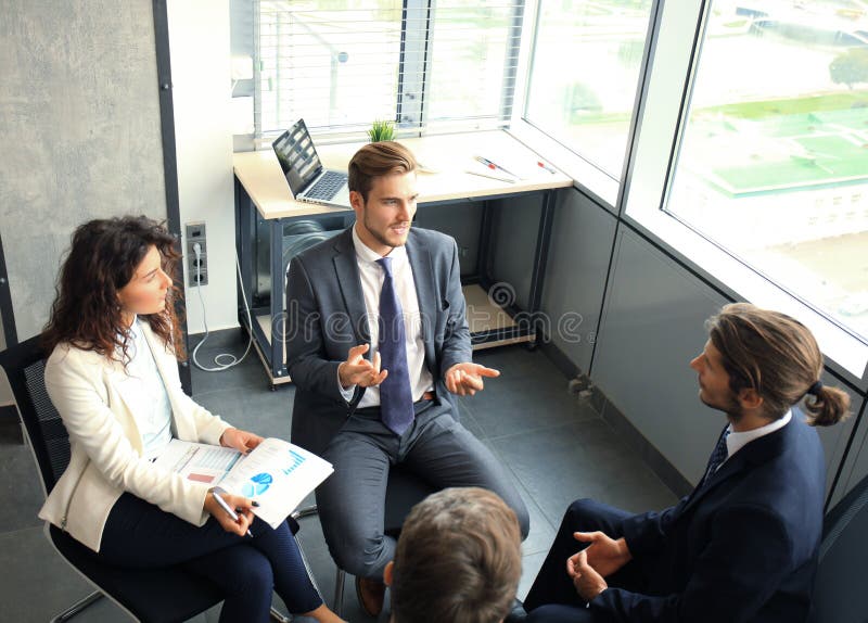 Creatieve bedrijfsmensen die in cirkel van stoelen samenkomen stock afbeelding