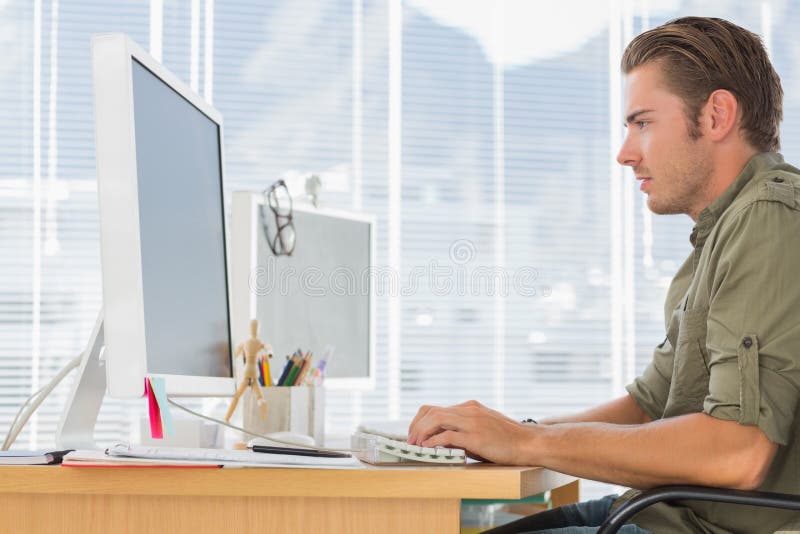 Creatieve bedrijfswerknemer die aan computer werken stock afbeelding Creatieve bedrijfswerknemer die aan computer werken stock afbeelding