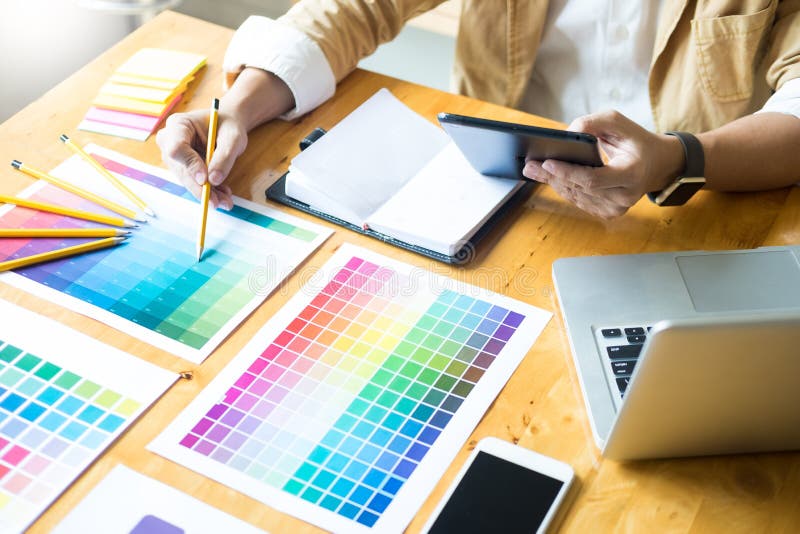 Creatieve Grafische Ontwerper op het Werk Het palet van de steekproevenpantone van het kleurenmonster in studio modern bureau, bi stock foto Creatieve Grafische Ontwerper op het Werk Het palet van de steekproevenpantone van het kleurenmonster in studio modern bureau, bi stock foto