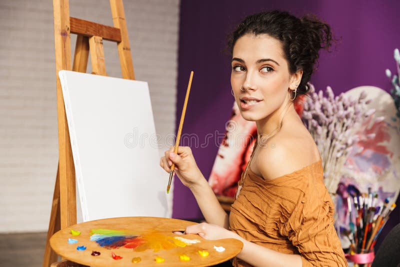 Creatieve mooie vrouw die thuis schilderen royalty-vrije stock fotografie Creatieve mooie vrouw die thuis schilderen royalty-vrije stock fotografie