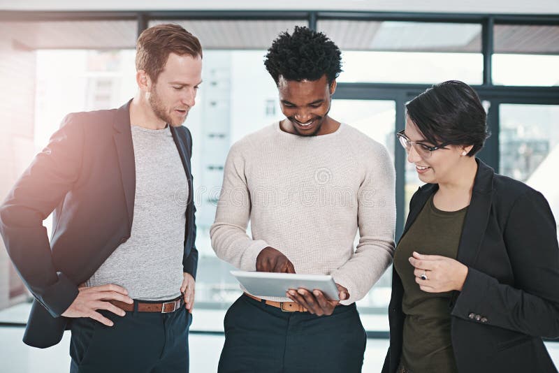 Creating a path forward as a team. businesspeople discussing something on a tablet. stock photography