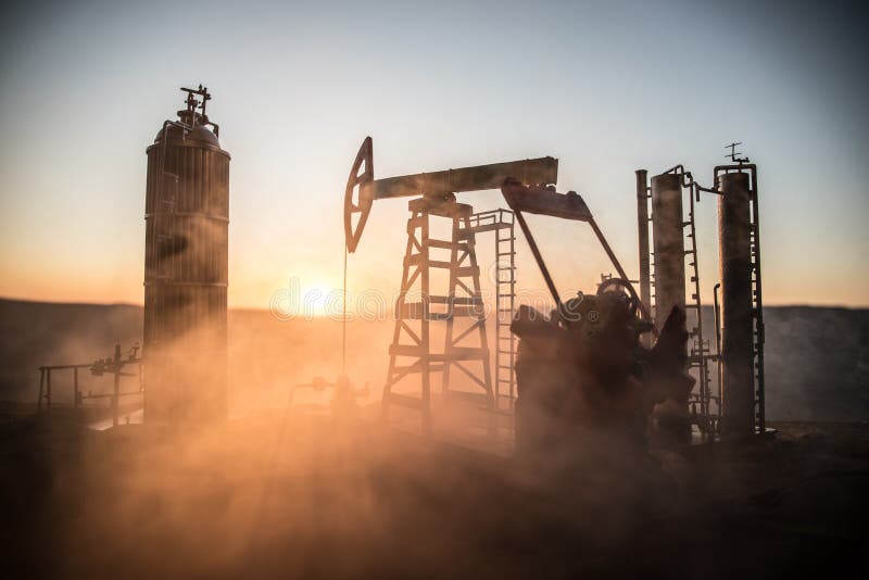 Creative artwork decoration. Oil pump and oil refining factory at sunset. Energy industrial concept. Selective focus