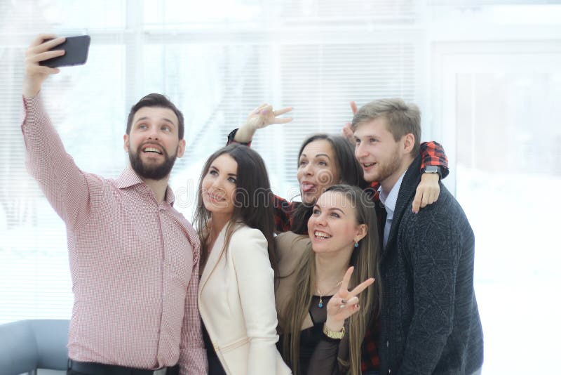 Creative business group takes selfies in a modern office royalty free stock photography Creative business group takes selfies in a modern office royalty free stock photography