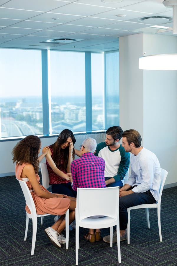 Creative business team consoling upset colleague at office