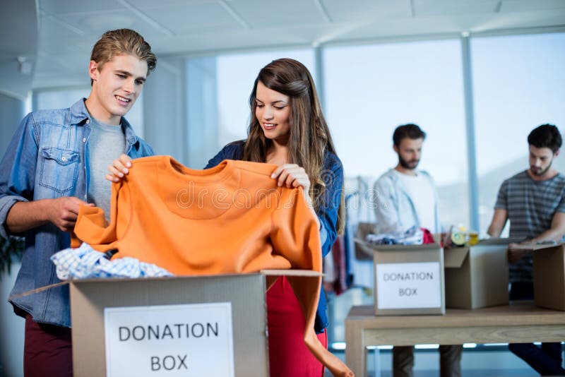 Creative Business Team Sorting Clothes in Donation Box Stock Photo