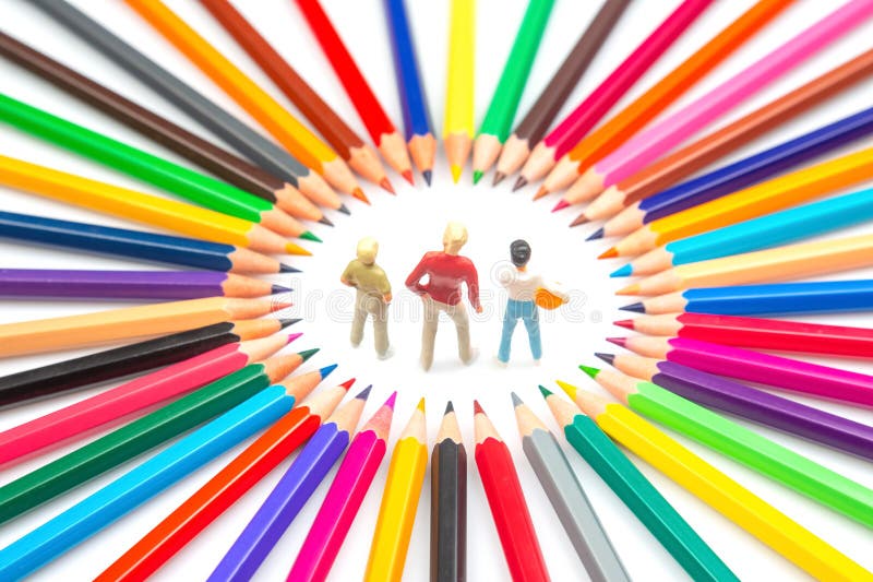 A creative composition featuring three small figures within a circle of assorted colored pencils, emphasizing art and royalty free stock image