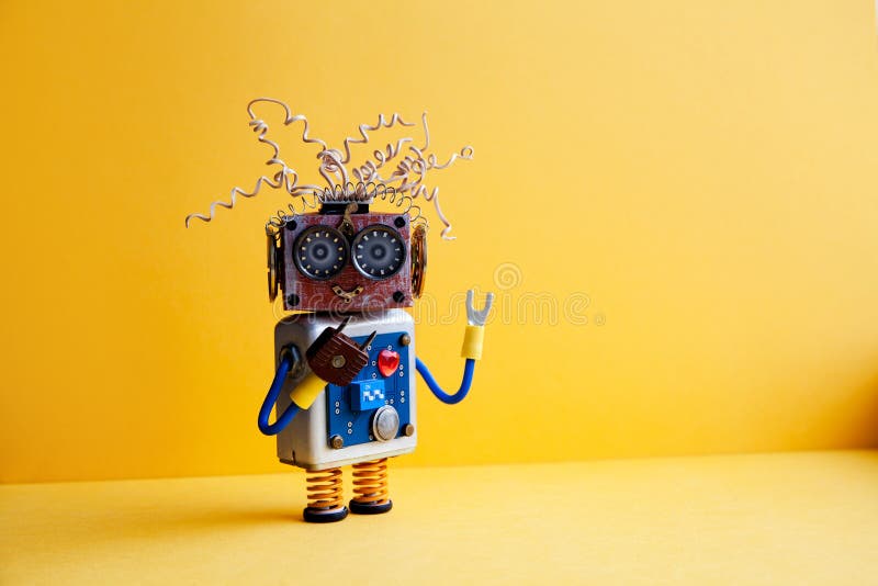 Creative design crazy robot toy, electric wires hairstyle, big eye glasses, electronic circuit blue silver body, red. Heart. yellow background. copy space royalty free stock photography Creative design crazy robot toy, electric wires hairstyle, big eye glasses, electronic circuit blue silver body, red. Heart. yellow background. copy space royalty free stock photography