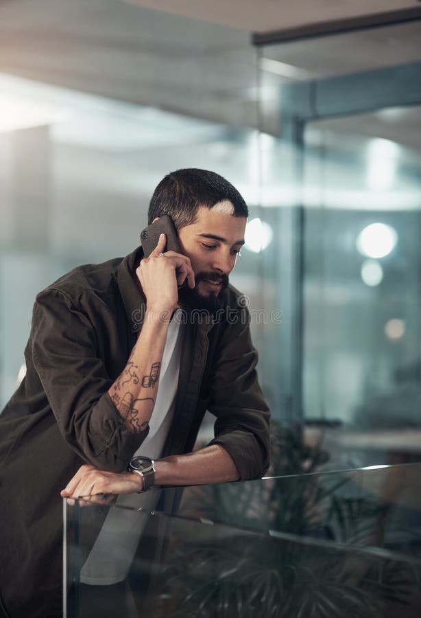 Creative, designer and man with phone call in startup with client for feedback, project update and task. Night, overtime royalty free stock photo