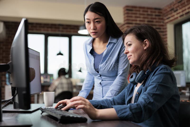 Creative designers developing digital arts on PC while discussing about 3D technology. royalty free stock image