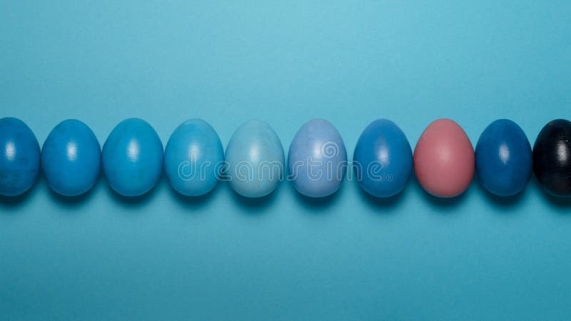 Creative Easter concept. Row Colorful Easter eggs of a blue gradient on a blue background. View from above stock photo