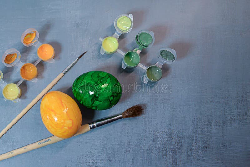 Creative Easter egg painting setup with a palette, paintbrushes, and a decorated egg , perfect for holiday DIY crafts. stock image