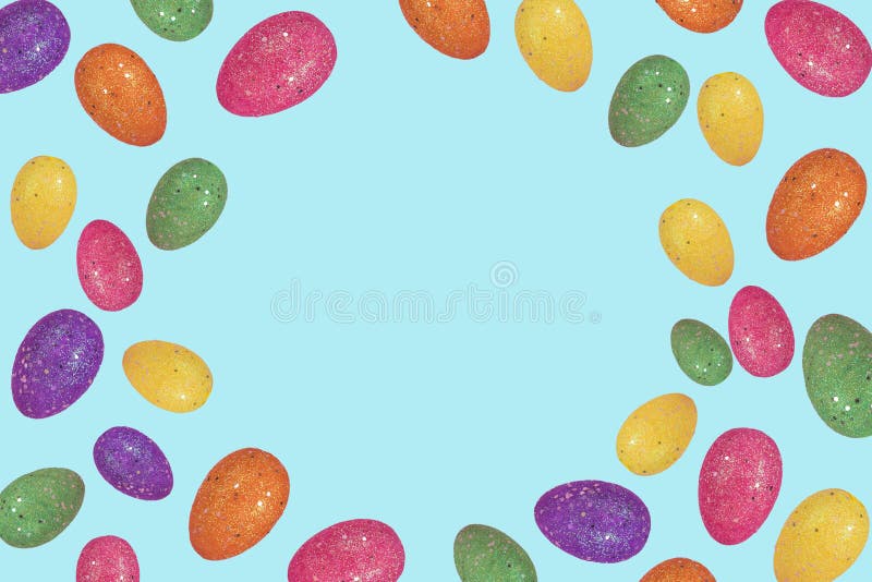 Creative Easter layout made of colorful eggs arranged on bright blue background with free space for text stock image