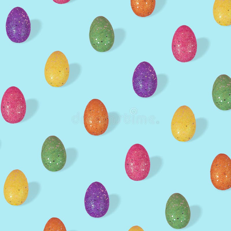 Creative Easter pattern made of colorful eggs arranged on bright blue background stock image