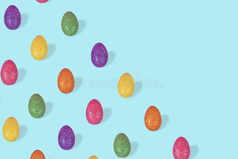 Creative Easter pattern made of colorful eggs arranged on pasel blue background royalty free stock photo