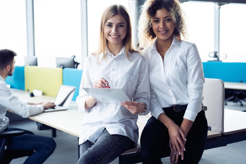 Creative female designers working in team. Two Businesswomen Having Informal Meeting In Modern Office. stock photo Creative female designers working in team. Two Businesswomen Having Informal Meeting In Modern Office. stock photo