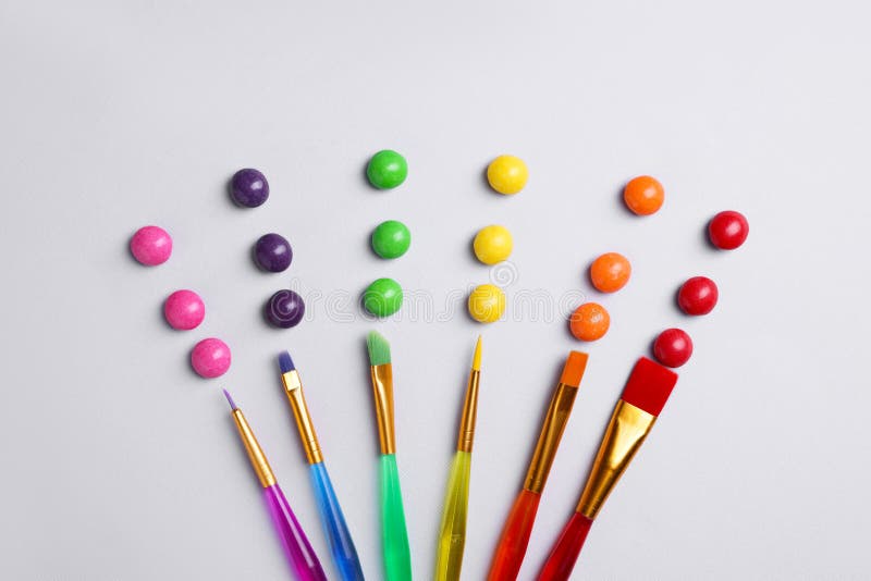 Creative Flat Lay Composition with Paint Brushes and Colorful Candies