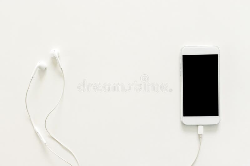 Creative flat lay photo of workspace desk with earphones and mobile phone with blank screen on copy space white background. stock image Creative flat lay photo of workspace desk with earphones and mobile phone with blank screen on copy space white background. stock image