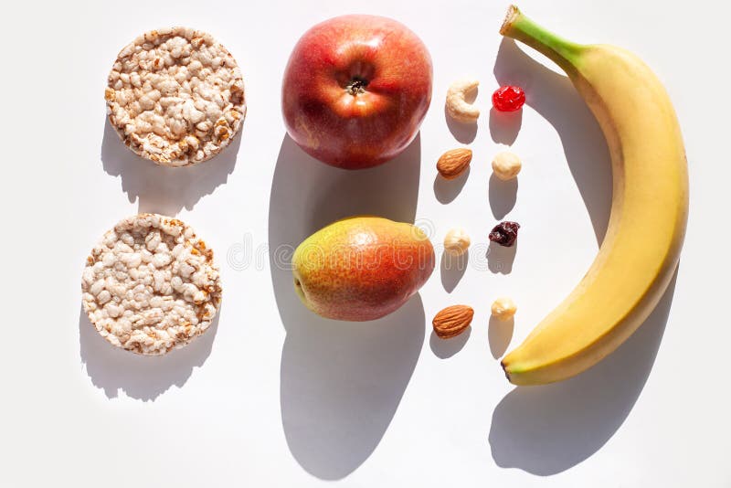 Creative healthy breakfast concept white background flat lay.Cheese,calcium rich food,nut, fruit, whole grain crispbread