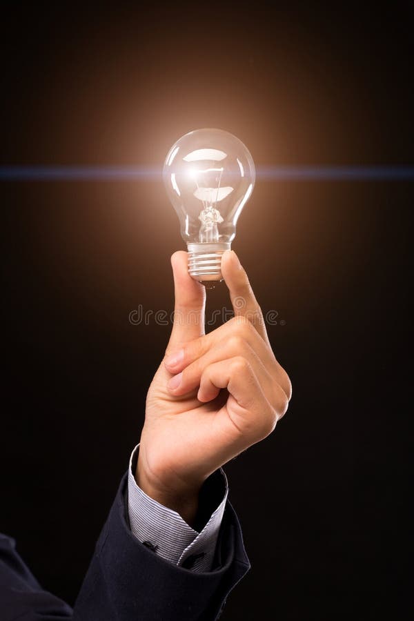 Creative idea bulb in man hand on black background