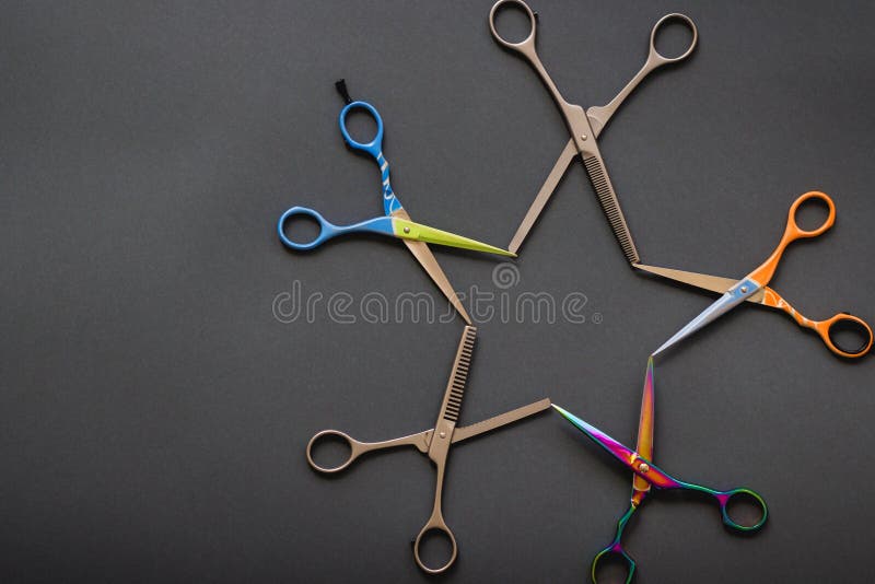 Creative layout made of professional hairdresser scissors in shape of a star on grey-black background. Flat lay stock photos Creative layout made of professional hairdresser scissors in shape of a star on grey-black background. Flat lay stock photos