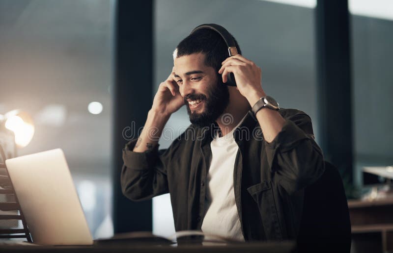 Creative, man and happy with laptop, headphones and video editor with night and idea for project. Content creation stock photos
