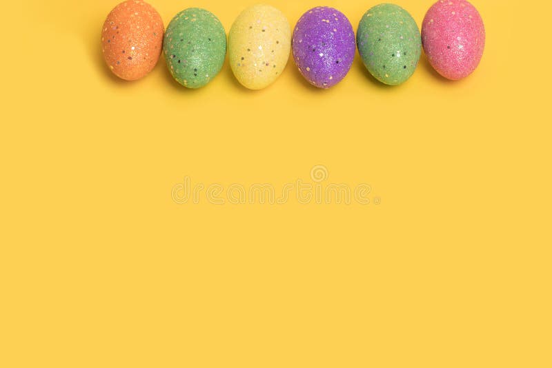 Creative Minimal Easter layout made of colorful eggs arranged diagonally on illuminating yellow and blue background royalty free stock images.