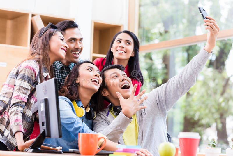 Creative team of five enthusiastic employees making a selfie photo