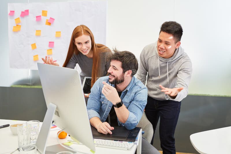 Creative team on the PC cheers on a developer stock images