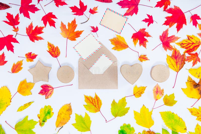 Creative Top view autumn composition. Envelope with flying out blank cards and row of handcrafted gift boxes on fallen leaves grad royalty free stock photo