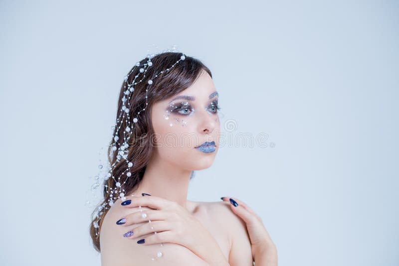 Creative, unusual closeup portrait of Snow Queen. Creative Winter Makeup. Perfect Beautiful Girl`s Face. Beautiful