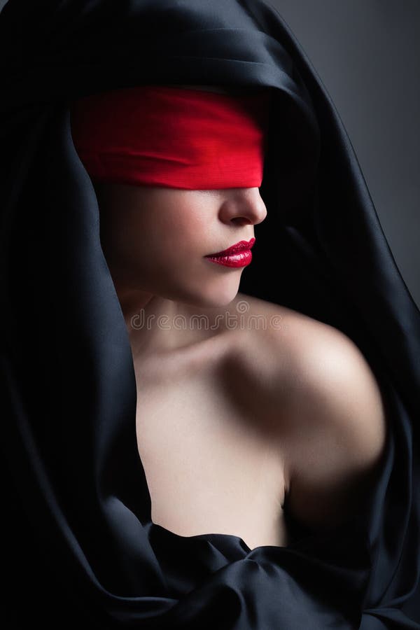 Woman portrait with red red blindfold and black satin covering head royalty free stock photos